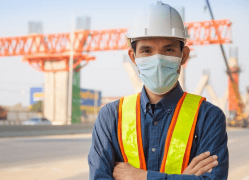 worker with ppe hard hat, face mask, and high visibility vest
