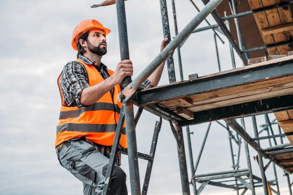 construction worker climbing scaffolding