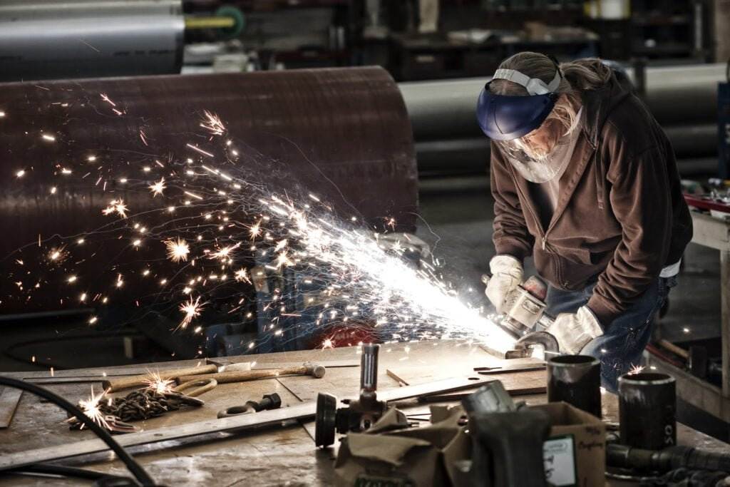 factory worker grinding sheet metal